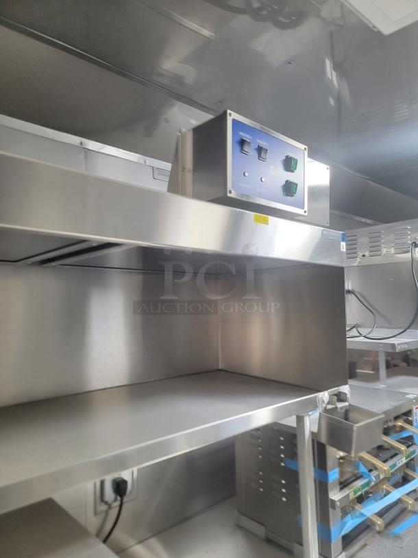 Stainless steel interior of a 2021 Texino FD-306 mobile kitchen, showcasing commercial-grade equipment, controls, and shelving.