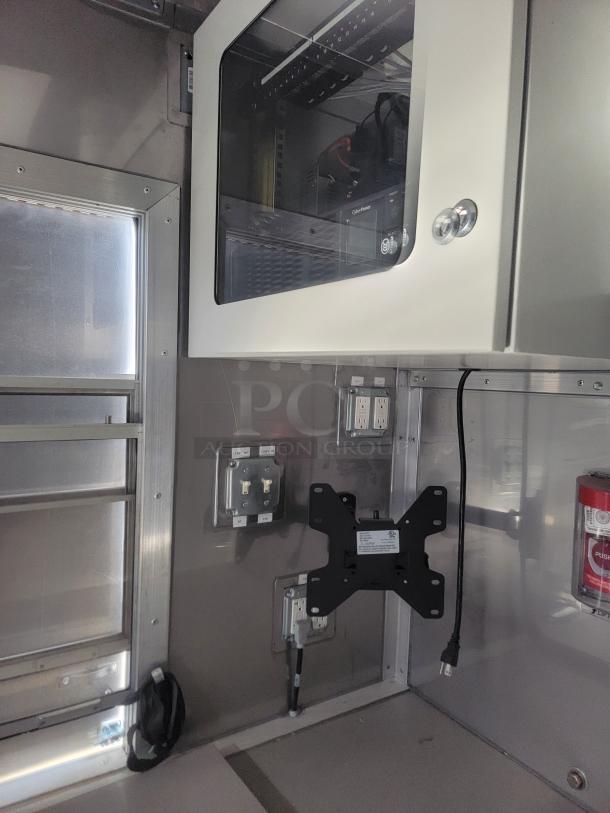 Interior of 2021 Texino FD-306 mobile kitchen, featuring stainless-steel surfaces, electrical outlets, a fire extinguisher, and mounted storage.
