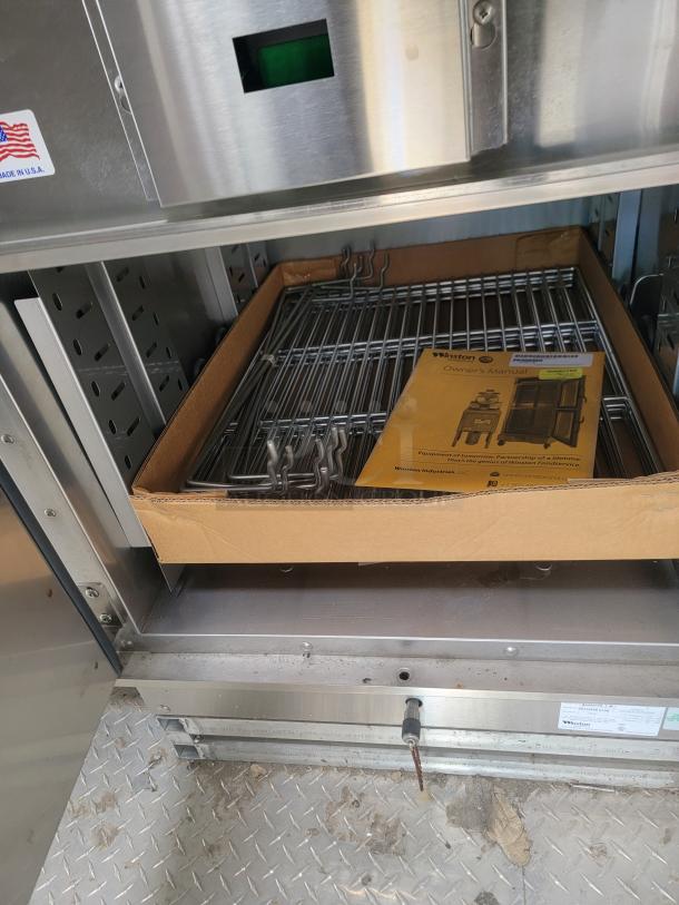 Stainless-steel convection oven interior with metal racks and Winston owner's manual. Needs cleaning for full restoration.