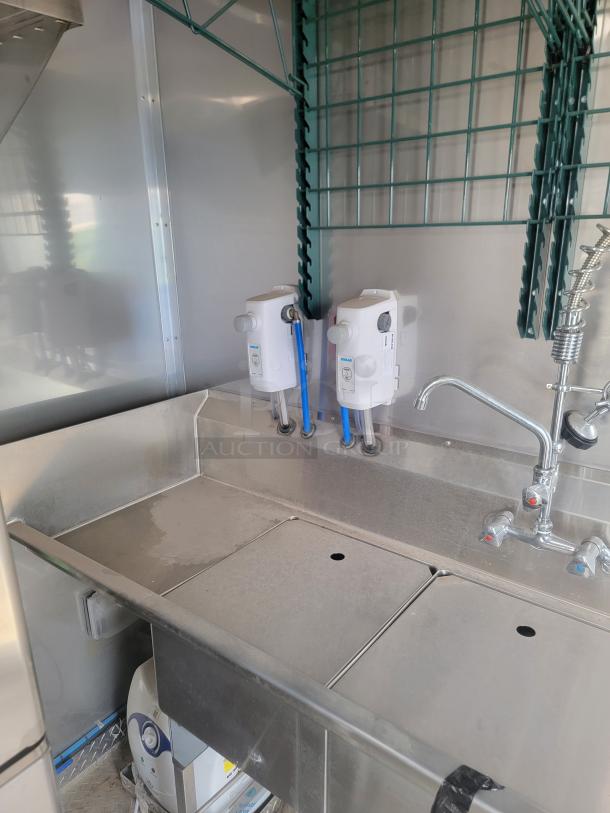 Stainless steel sink in 2021 Texino FD-306 mobile kitchen, featuring dual soap dispensers and industrial faucet. Needs cleaning.