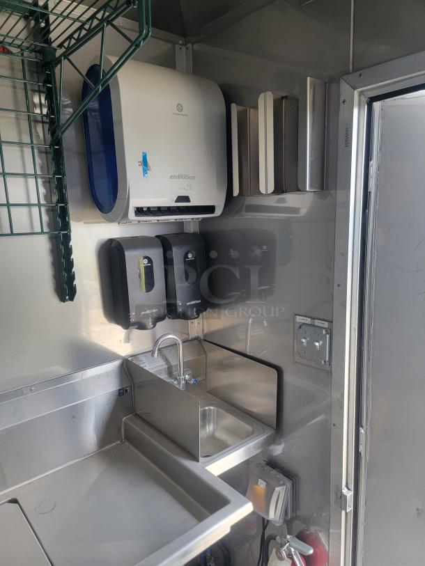 Interior of a 2021 Texino FD-306 mobile kitchen featuring a stainless-steel sink, enMotion dispensers, and utility outlets.