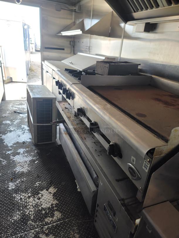 2020 Diamond Cargo mobile kitchen interior with Wells griddle and range, Arctic Air fridge/freezer, stainless steel surfaces.
