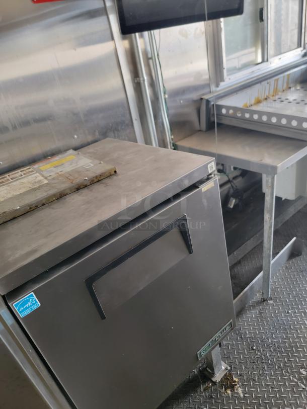 2020 Diamond Cargo mobile kitchen interior; features Arctic Air refrigerator, stainless surfaces, True manufacturing prep station.