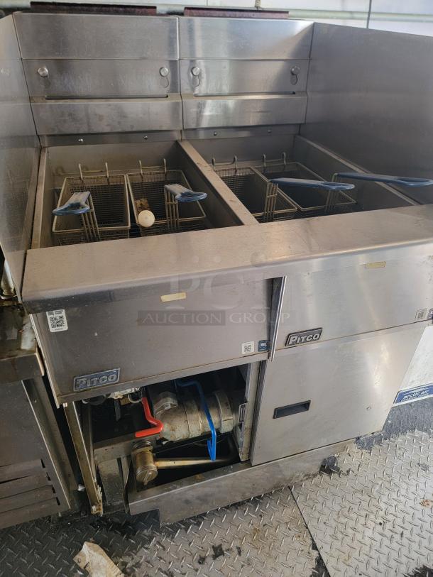 Pitco commercial fryer with dual baskets in Diamond Cargo 24' mobile kitchen. Features sturdy stainless steel construction, ideal for high-volume cooking.