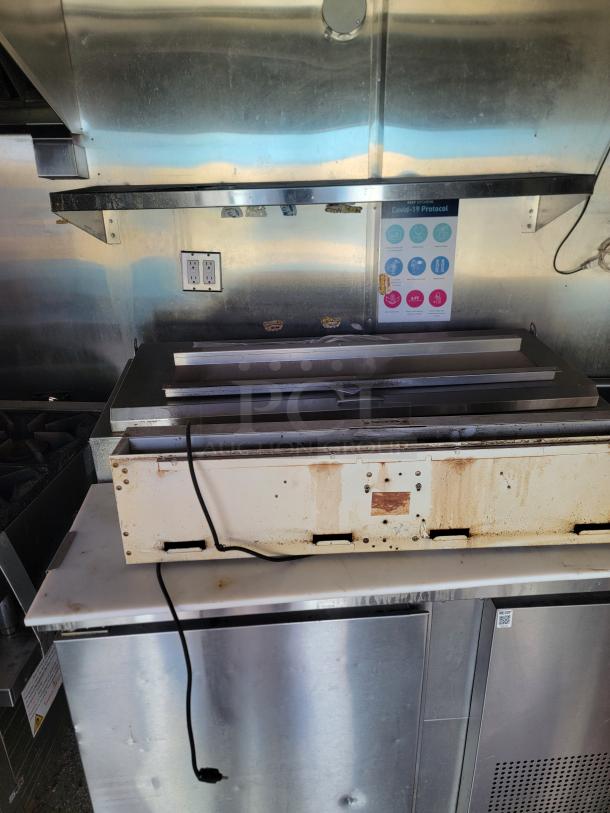 2019 Quality Cargo 8.5x24 TA3 mobile kitchen interior, showing a metal prep area needing cleaning, with plugged-in appliances.