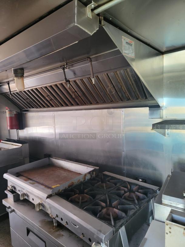 2019 Quality Cargo 24' mobile kitchen interior with Garland 4-burner range, griddle, vent hood needing cleaning and TLC.