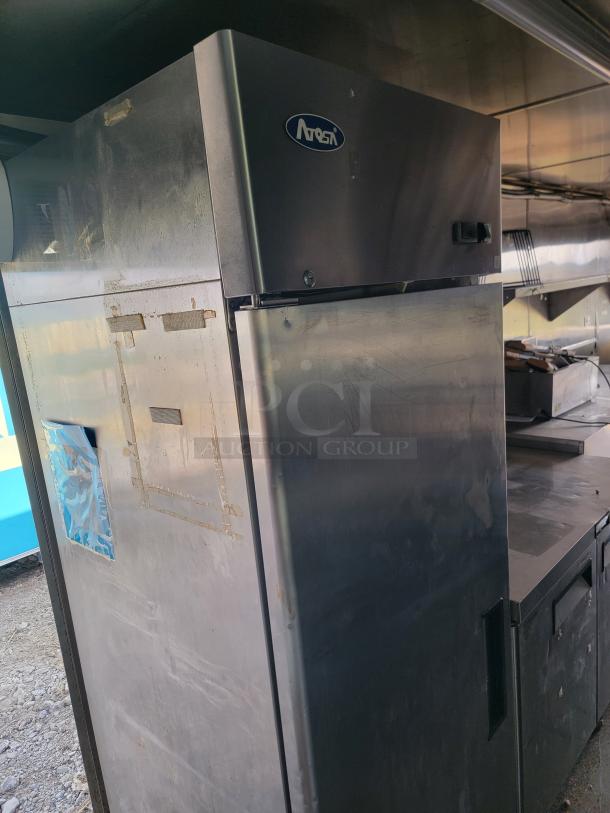 Quality Cargo mobile kitchen interior showing Arosa fridge. Needs cleaning. Features Garland range and Mirage VentusX HVAC.