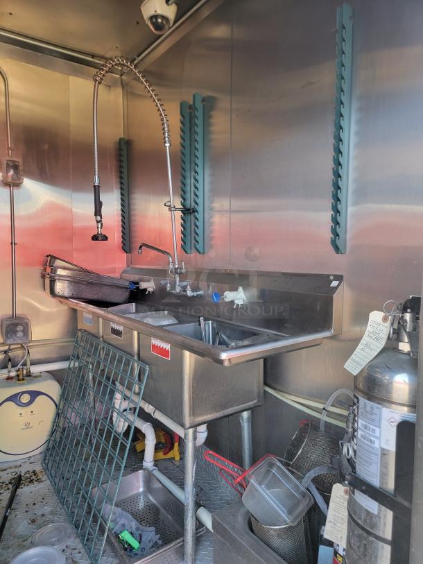 2021 Diamond Cargo 24' mobile kitchen interior with stainless steel triple sink, fire suppression system, and commercial fixtures.
