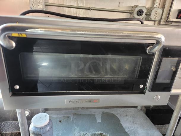 Stainless steel commercial oven in a 2021 Diamond Cargo mobile kitchen, showing Pratica Forza 5i branding.