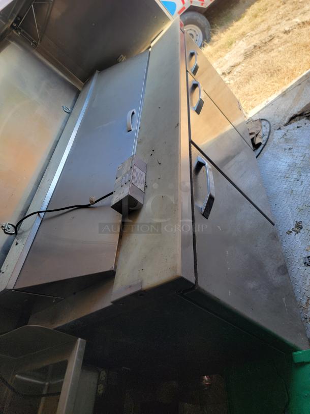 2021 Diamond Cargo 24' food trailer interior with stainless steel cabinets. Needs cleaning. Durable and spacious for heavy use.