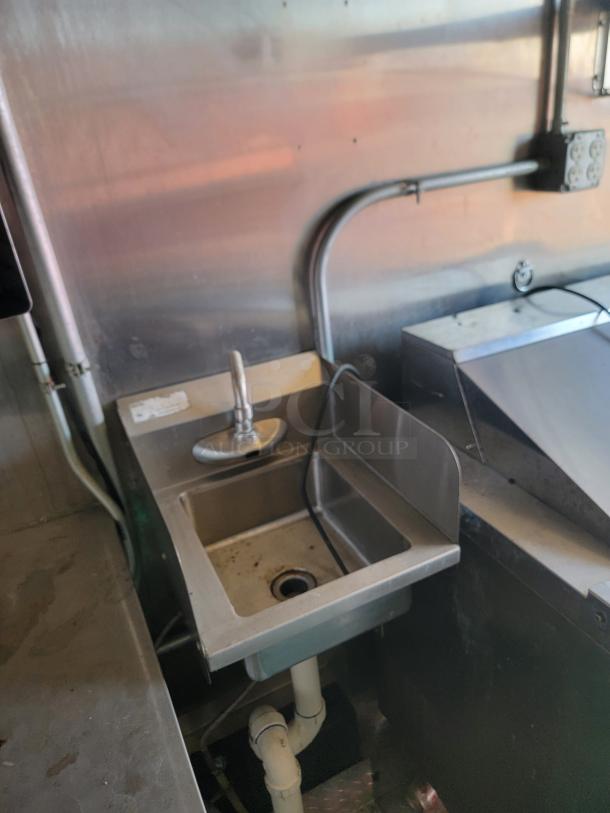 Industrial stainless steel sink inside a 2021 Diamond Cargo 24' food trailer; slight wear visible, ready for cleanup.