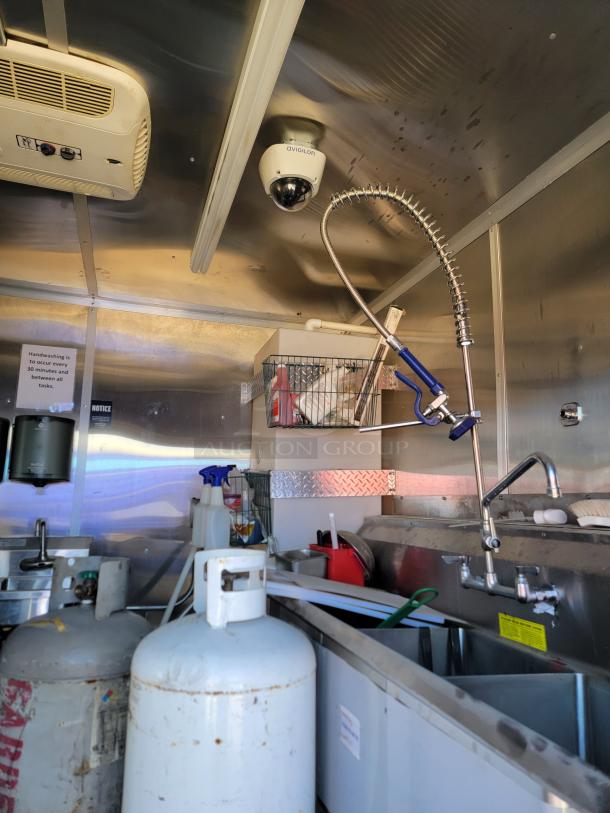 2021 Diamond Cargo mobile kitchen interior showing Avigilon security camera, propane tanks, and kitchen sink area.