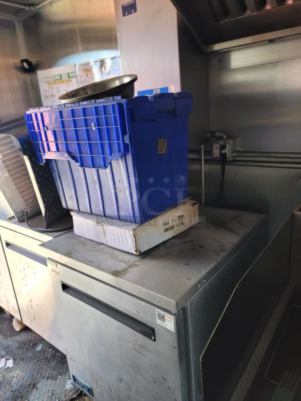 2021 Diamond Cargo mobile kitchen interior showing Arctic Air refrigeration unit with blue storage bin on top.