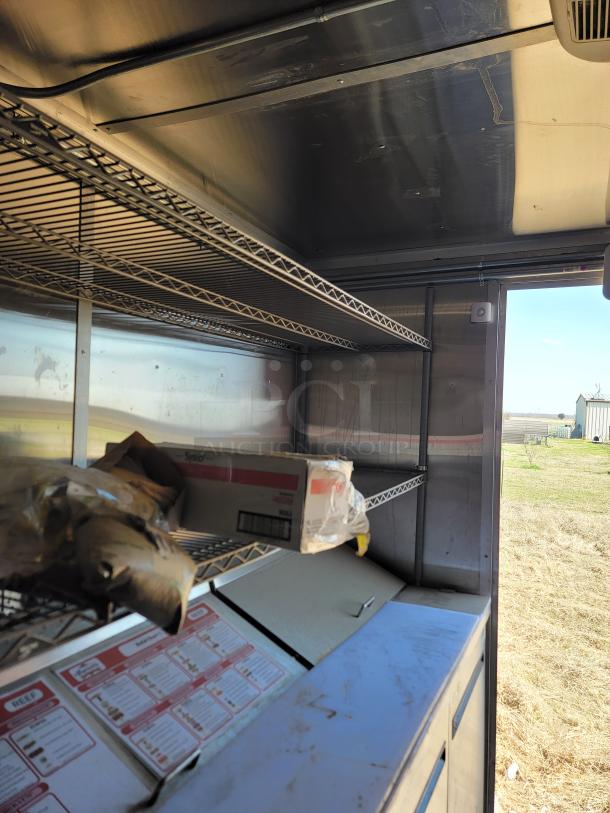 Interior of a 2021 Diamond Cargo 24' mobile kitchen showing storage shelves and equipment. Clean and well-maintained.