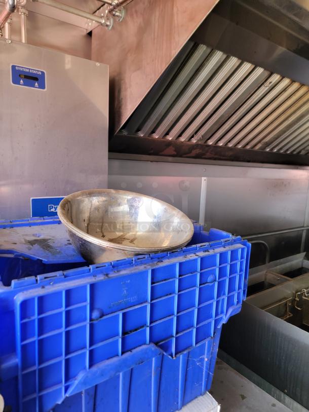 Stainless steel bowl on a blue plastic crate inside a 2021 Diamond Cargo mobile kitchen, showing ventilation system.
