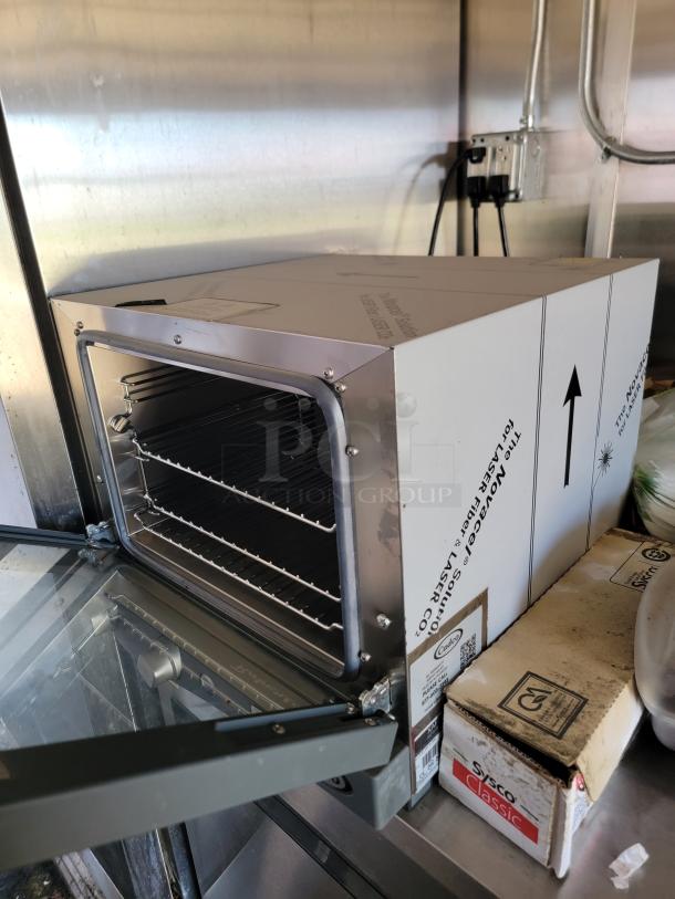 Stainless steel oven inside 2021 Diamond Cargo mobile kitchen, featuring a glass door and wire racks. Appears in good condition.