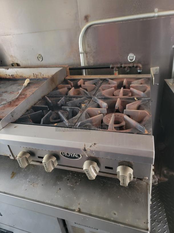 Professional-grade Royal stovetop in a 2021 Diamond Cargo mobile kitchen, showing signs of light use. Features manual controls.