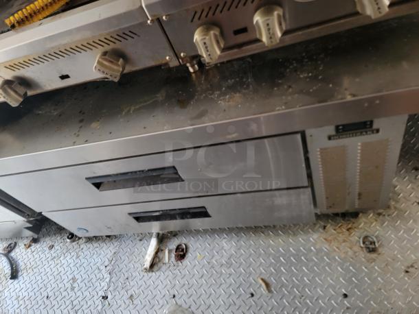 Interior of 2021 Diamond Cargo 24' mobile kitchen with stainless steel cabinets and industrial equipment, showing signs of use.