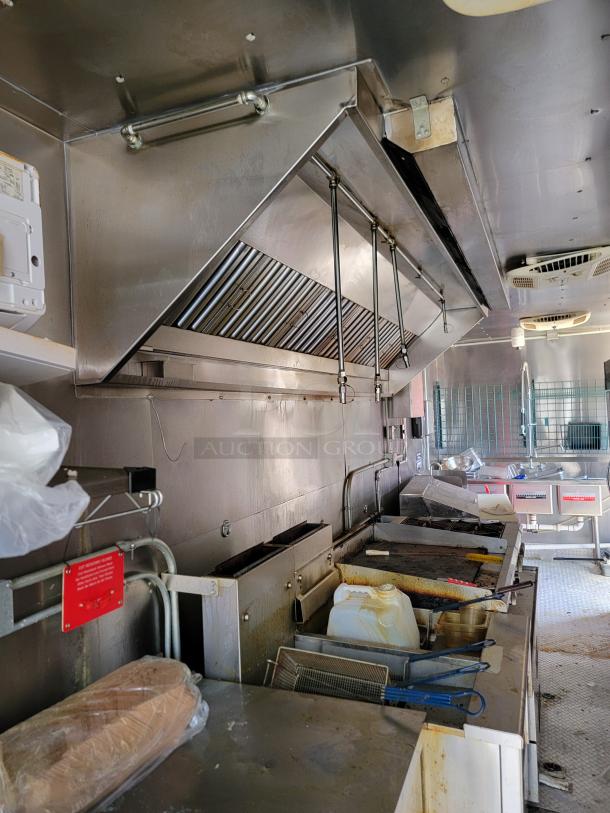 24' Diamond Cargo mobile kitchen interior with industrial CaptiveAire ventilation, griddle, fryers, and storage space, 2021 model.