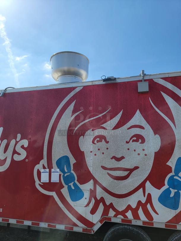 2021 Rock Solid Cargo 28’ mobile kitchen with ventilation hood, vibrant graphics, and triple axle stability for catering.