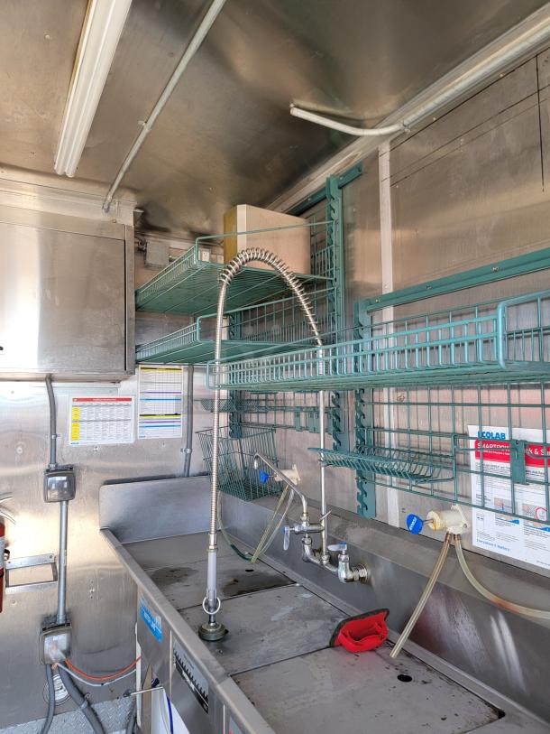 2021 Rock Solid Cargo 28' mobile kitchen interior with Ecolab SmartPower™ station, 3-compartment sink, and rooftop ventilation.