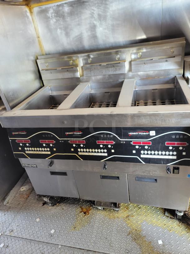 Henny Penny Evolution Elite fryer in stainless steel, featuring digital controls and multiple fry baskets, used condition.