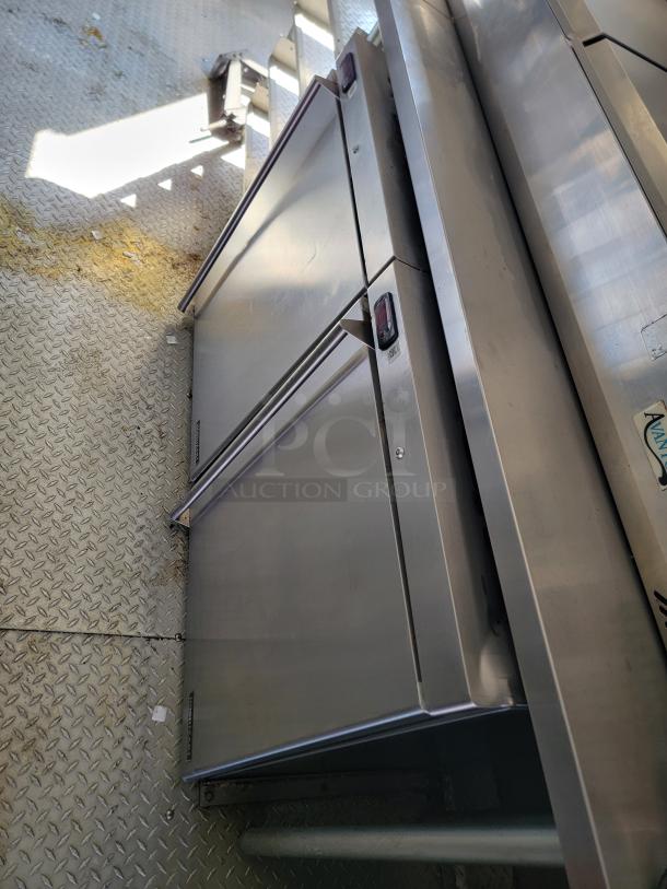 Stainless steel commercial fridge in 2021 Rock Solid Cargo mobile kitchen, excellent condition, durable for high-volume use.