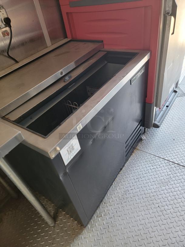 2021 Rock Solid Cargo 28’ mobile kitchen interior, featuring a stainless-steel refrigeration unit with ventilation and utility connections.