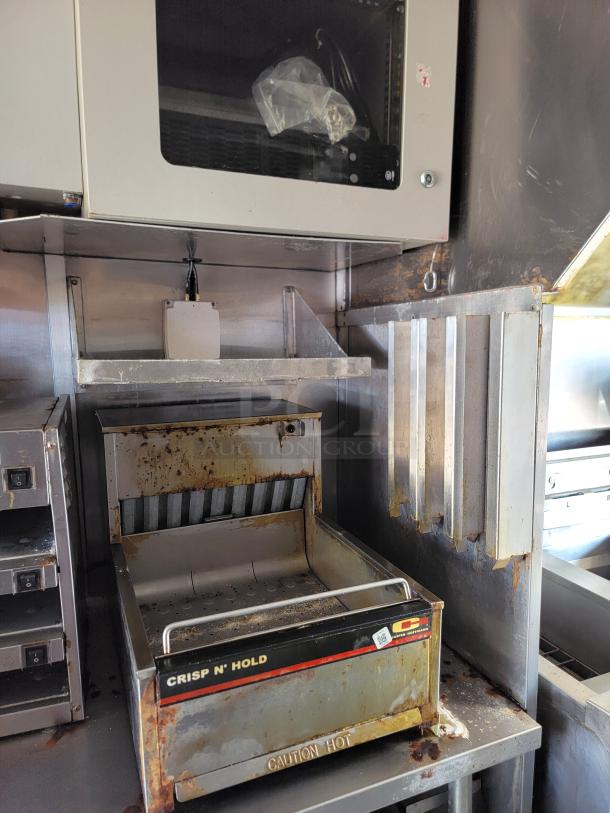 2021 Rock Solid Cargo mobile kitchen interior, showing a commercial food warmer labeled "Crisp N' Hold." Signs of wear and rust visible.