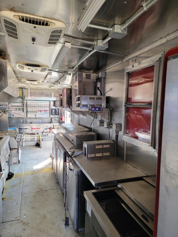 2021 Rock Solid Cargo 28’ triple axle mobile kitchen interior with commercial sinks, ventilation, and equipment.