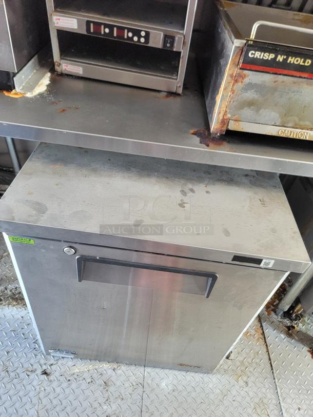 2021 Rock Solid Cargo 28’ mobile kitchen interior with stainless steel appliances, including a commercial oven and fryer, showing signs of use.