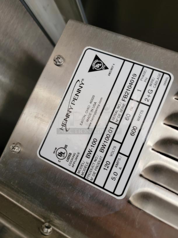 Plaque on Henny Penny appliance, model BW-100, with serial number FB2104019, 120V, 5A, 60Hz, UL listed.