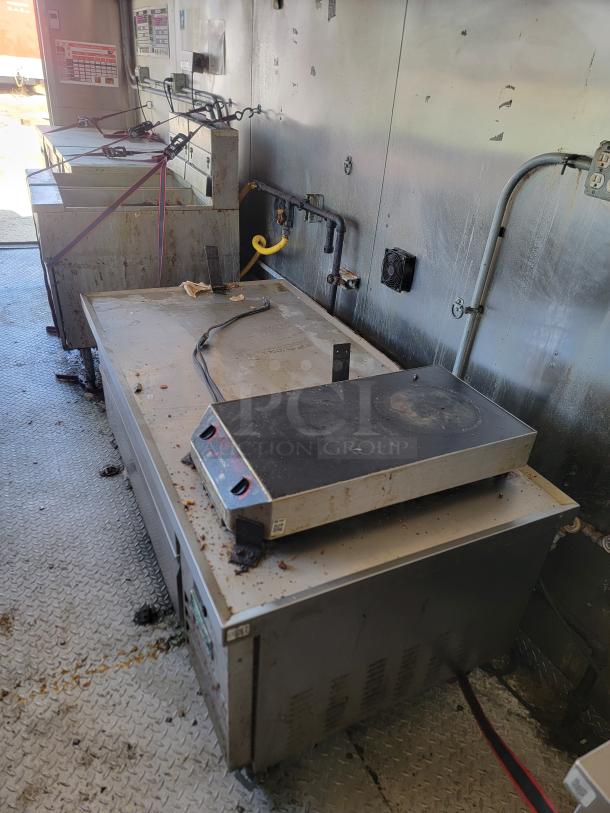 Interior view of a 2020 Diamond Cargo 28' food trailer showing cooking equipment and electrical setup, moderate wear.