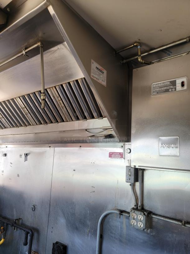 Interior view of a 2020 Diamond Cargo 28' food trailer with a Hoodz vent and Ansul fire suppression system for safety.