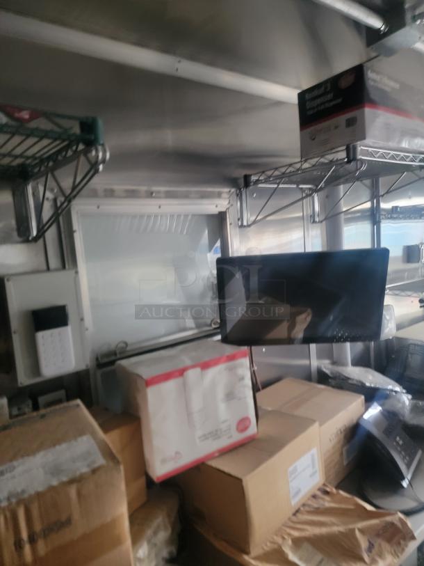 2021 Rock Solid Cargo 8.5' x 24' Ghost Kitchen Trailer interior with shelves, boxes, and monitor.