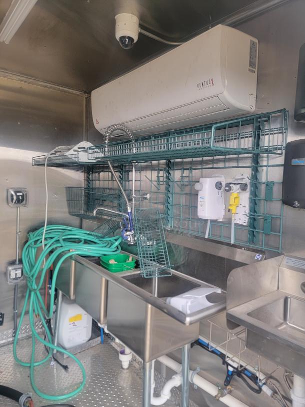 2021 Rock Solid Cargo food trailer interior with stainless steel sinks, hoses, and Ventus mini-split HVAC.