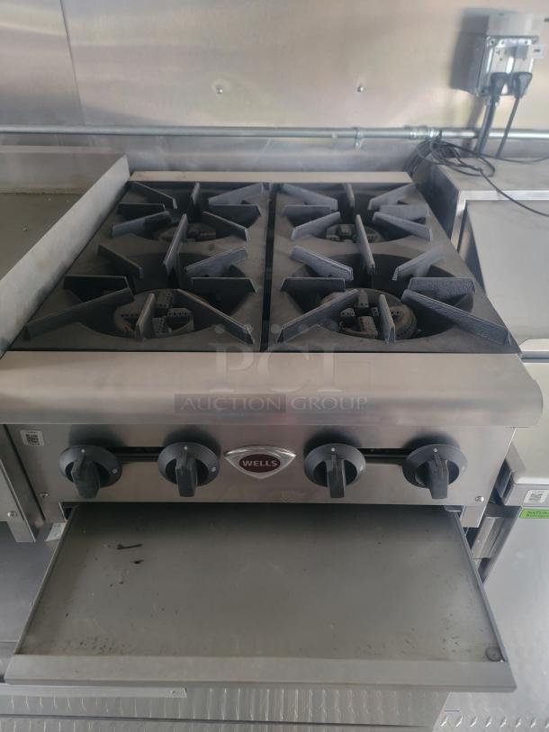 Wells griddle in 2021 Rock Solid Cargo 8.5' x 24' food trailer, featuring control knobs and stainless steel surface.