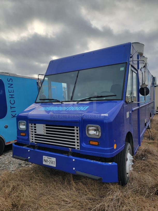 Blue food truck with "neighborhood" branding, Texas license plate WMR-2683. Good exterior condition, parked on grass.