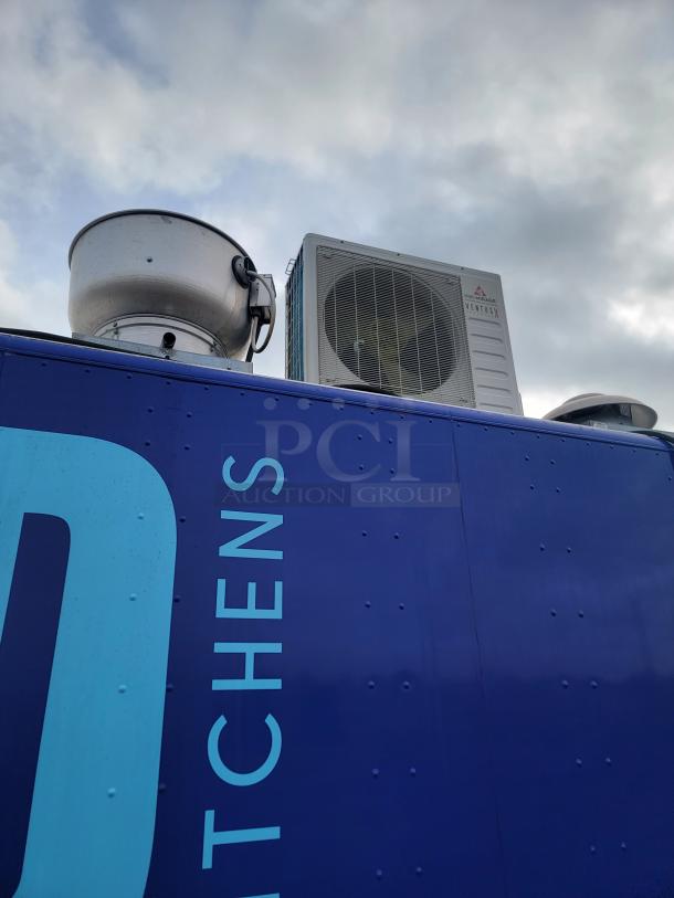 Industrial rooftop ventilation system on blue structure. Features a ventilation fan and air conditioning unit marked "VENTUX".