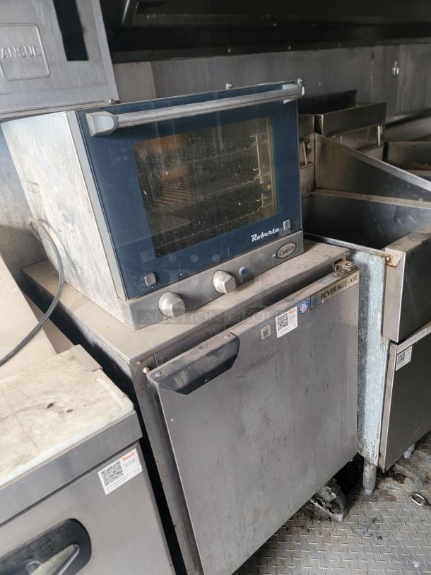 Commercial countertop convection oven, Cadco brand, used condition. Features include a glass door and two control knobs.