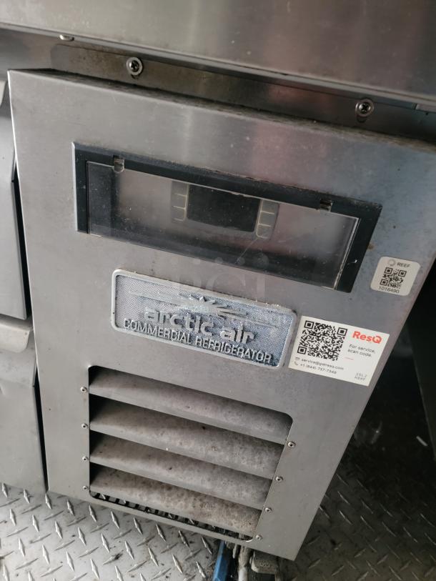 Arctic Air commercial refrigerator in used condition, featuring a digital display and vent. Includes service QR code and contact info.