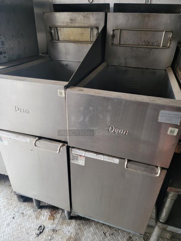 Two Dean commercial deep fryers in used condition with visible wear, featuring stainless steel construction and functional lids.