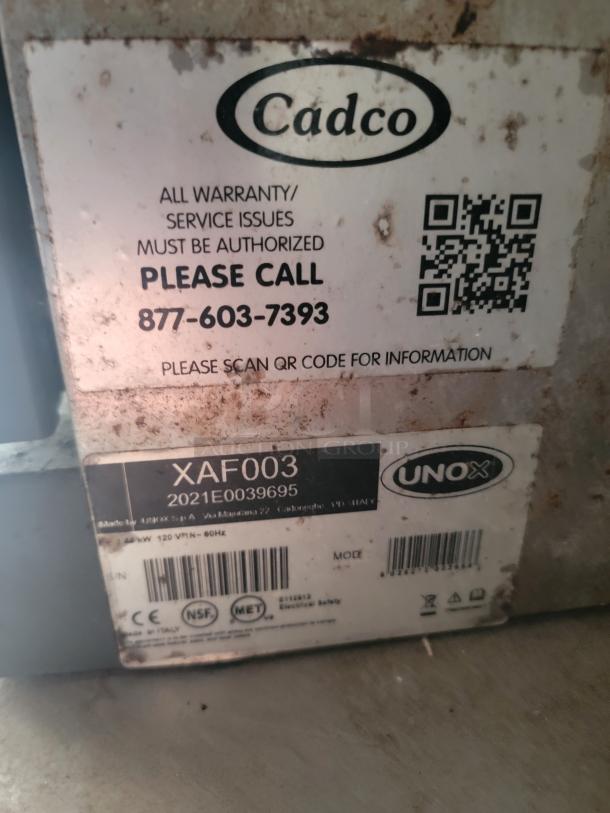 Label on Cadco XAF003 oven with warranty contact info and QR code. Model and serial number visible. Used condition.