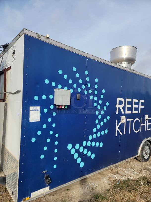 Blue mobile kitchen trailer with "REEF KITCHEN" text, circular dot design, exhaust vent, and visible inspection checklist.
