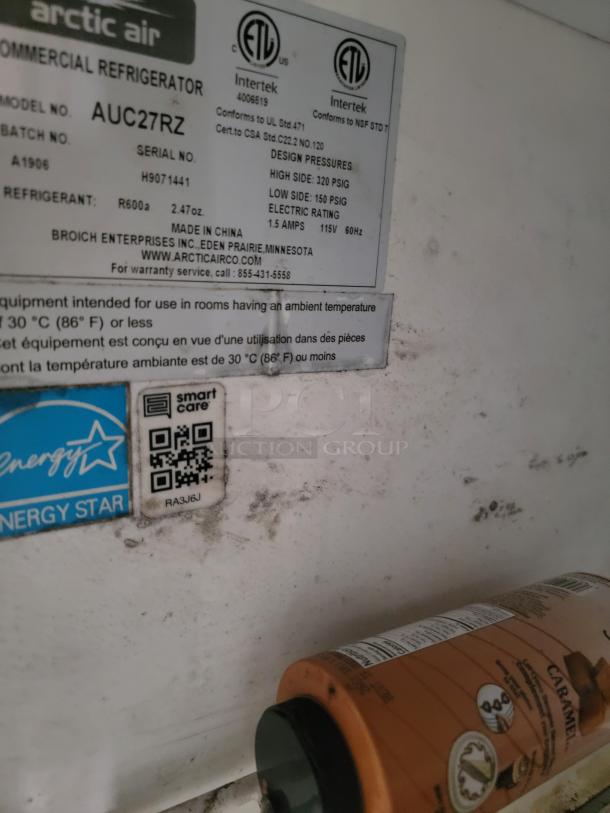 Arctic Air model AUC27RZ commercial refrigerator label showing specifications, Energy Star sticker, and some visible wear.