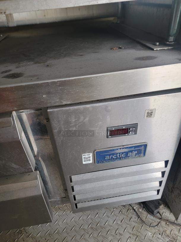 Arctic Air commercial refrigerator, stainless steel, digital display, visible scuffs, QR code, suitable for businesses.