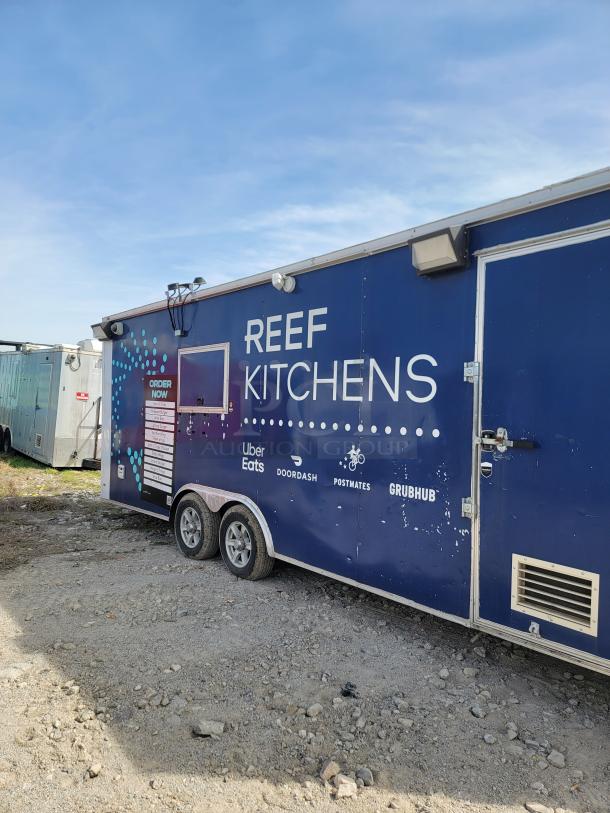 Mobile kitchen trailer with "REEF KITCHENS" branding, associated with Uber Eats, DoorDash, Postmates, Grubhub. Blue exterior in fair condition.