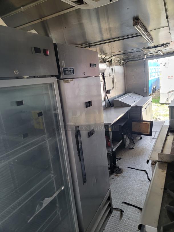 Commercial kitchen interior with Arctic Air refrigerator, stainless steel surfaces, and prep station.
