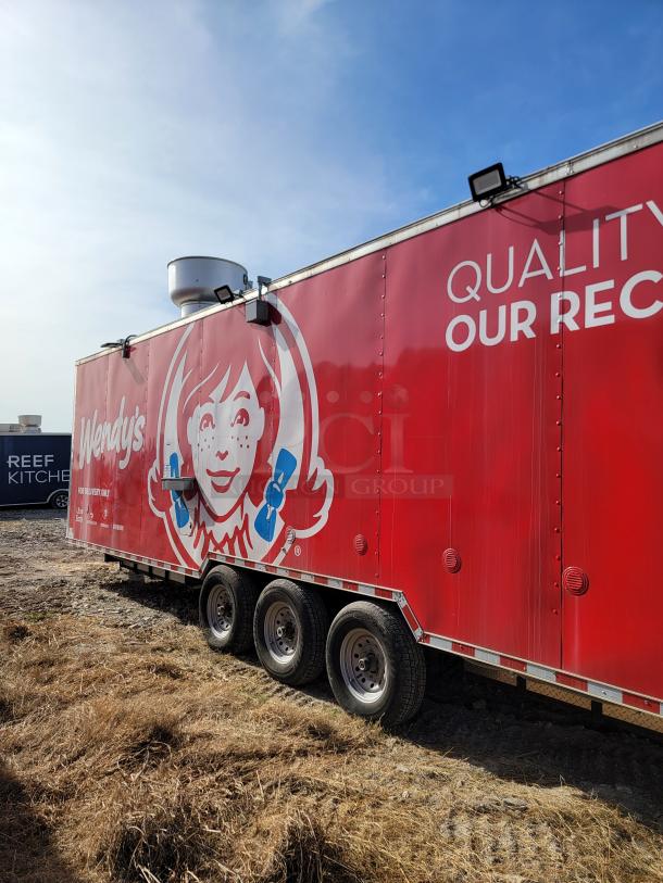 Red Wendy's food trailer with logo, triple-axle wheels, and "Quality is Our Recipe" slogan. Vent and lights on roof.