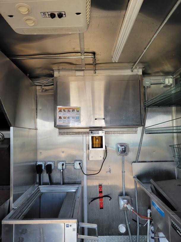 Commercial kitchen interior with stainless steel surfaces, multiple electrical outlets, and ventilation equipment. Used condition.